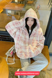 Person wearing a plaid jacket in a casual setting with a visible brand watermark.