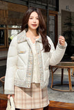 Woman wearing a white puffer jacket with decorative trim outdoors.