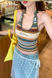 Woman wearing a colorful striped tank top with 'Disney' branding, holding a yellow bag indoors.