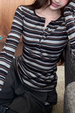 Person wearing a striped long-sleeve shirt sitting on a couch.