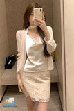 Woman taking a mirror selfie wearing a white lace outfit.