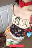 Person wearing a floral top and skirt with colorful accessories indoors.