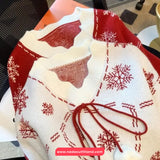 Red and white patterned sweater with a visible brand logo on a chair.