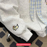 Gray hoodie with cartoon chicken design on sleeve, sitting on a chair.