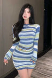 Woman wearing a colorful striped dress indoors.