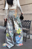 Person wearing floral and text-patterned pants standing on a sidewalk.