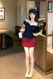 Woman in a blue top and red skirt standing in a cafe.