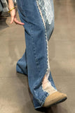 Blue jeans with lace trim worn by a person on a neutral floor.