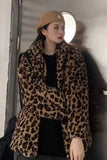 Person wearing a leopard print coat and beige beret indoors.