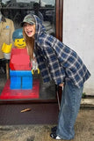 Person leaning against a glass door with a toy figure of a lego-like character inside.
