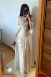 Woman taking a mirror selfie wearing a white polka dot dress in a room.