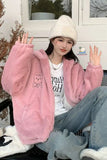 Person wearing a pink fleece jacket and white beanie outdoors