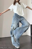 Person wearing a white top and light blue jeans in an indoor setting