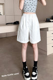 Person wearing a star-patterned crop top and white shorts in an indoor setting.