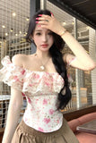 Woman wearing a floral off-shoulder top with a blurred background