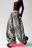 Leopard print pants worn by a person on a gray background with 'nadaoutfitland.com' branding.
