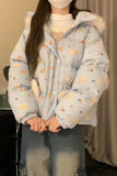 Person wearing a light blue puffer jacket with animal patterns indoors.