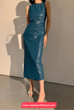 Woman wearing a blue dress against a neutral background with a visible brand name.