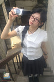 Person taking a selfie with a vintage camera on a staircase