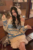 Woman wearing a patterned sweater and white earmuffs in an indoor setting