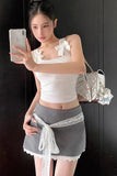 Woman taking a mirror selfie wearing a white top and gray skirt with lace details.