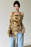 A woman modeling a brown and beige tie-dye halter top with long draped sleeves, paired with light blue jeans, against a plain off-white wall.