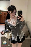 Person taking a mirror selfie wearing a gray blouse with lace details and black shorts.