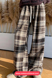 Plaid pants worn by a person with decorative pampas grass in the background