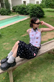 Woman sitting on a wooden bench by a pool with sunglasses on