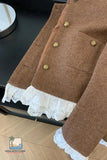 Brown textured jacket with lace trim on a black surface