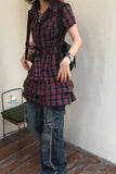 Person wearing a plaid dress and jeans indoors.