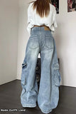 Person wearing light blue wide-leg jeans and a white shirt in an indoor setting.