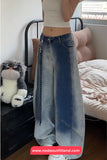 Person wearing blue jeans with a blurred face in a bedroom setting