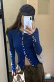 Person wearing a blue cardigan and black cap taking a mirror selfie.