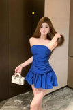 Woman in a blue strapless dress posing indoors.