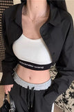 Person wearing a black jacket over a white top with 'alexanderwang' branding, standing indoors.