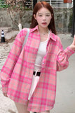 Person wearing a pink plaid shirt outdoors