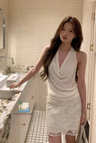 Woman in a white dress standing in a bathroom.