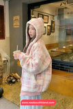 Person wearing a pink and white checkered hoodie in a casual setting