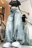 Person wearing oversized distressed jeans and a black crop top in an indoor setting.