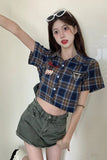 Woman wearing a plaid shirt and denim shorts with sunglasses on her head.