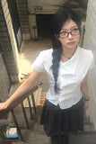 Woman wearing a white blouse and black skirt standing on a staircase.