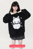 Person wearing a black sweater with a white cat design on a plain background