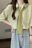 Person wearing a striped shirt with a green scarf in an indoor setting