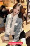 Woman wearing a stylish outfit with a textured jacket and white fur lining, sitting in an indoor setting.