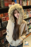 Person wearing a fur-lined hooded jacket in a bookstore