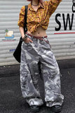Person wearing a yellow plaid shirt and camouflage pants standing in front of a metal shutter.