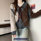 Person wearing a patterned sweater with a bow tie in an indoor setting