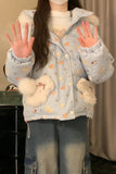 Person wearing a light blue jacket with animal patterns and fluffy cuffs, holding hands up.