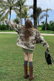 Person wearing a floral jacket in a park with palm trees